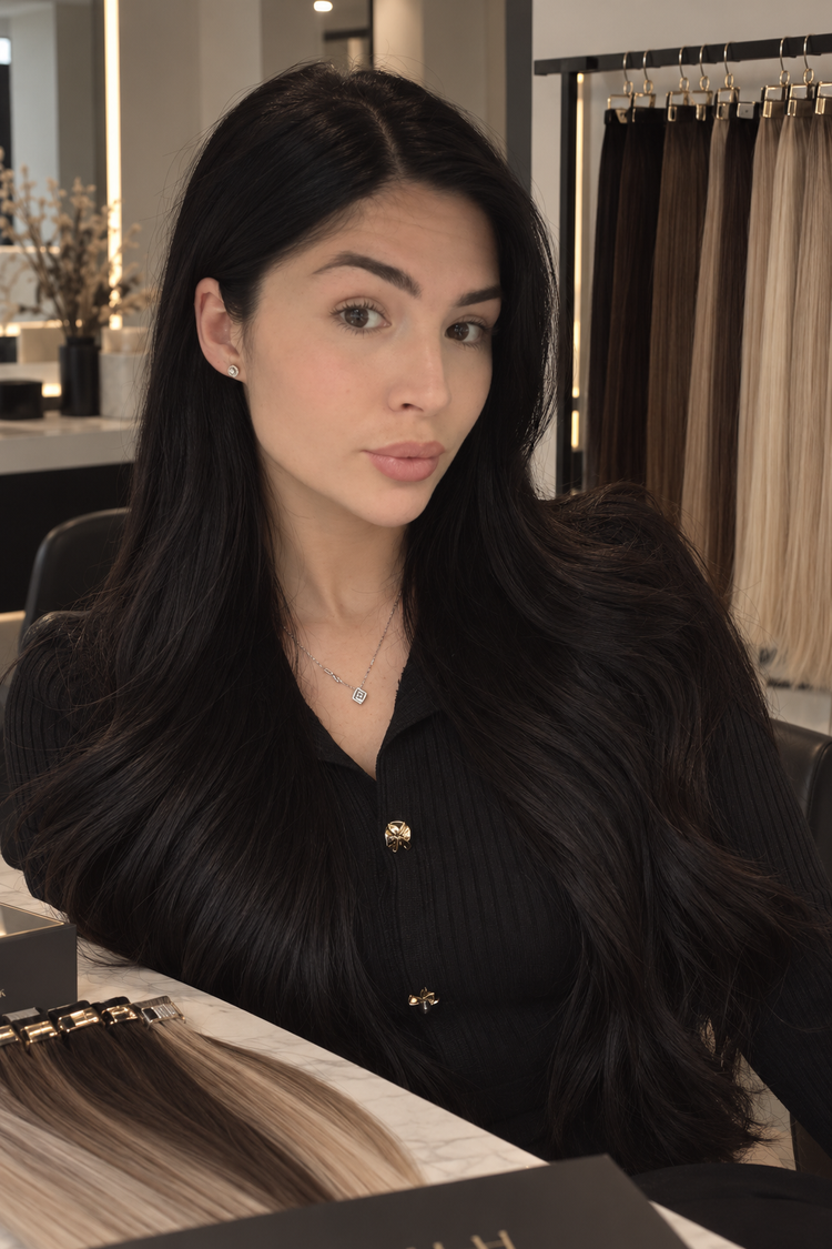 Lulah with long, glossy dark hair extensions in the salon
